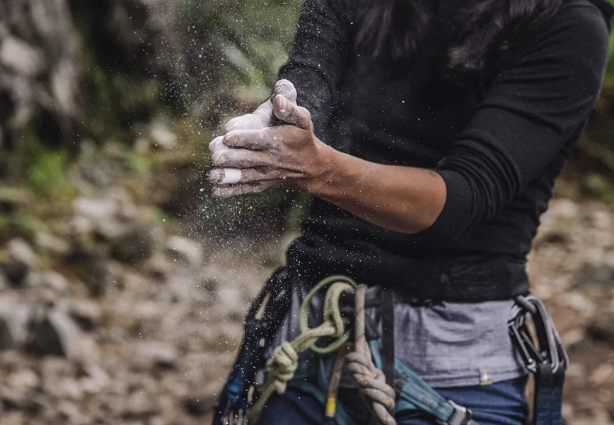 Why do rock climbers use chalk instead of gloves?